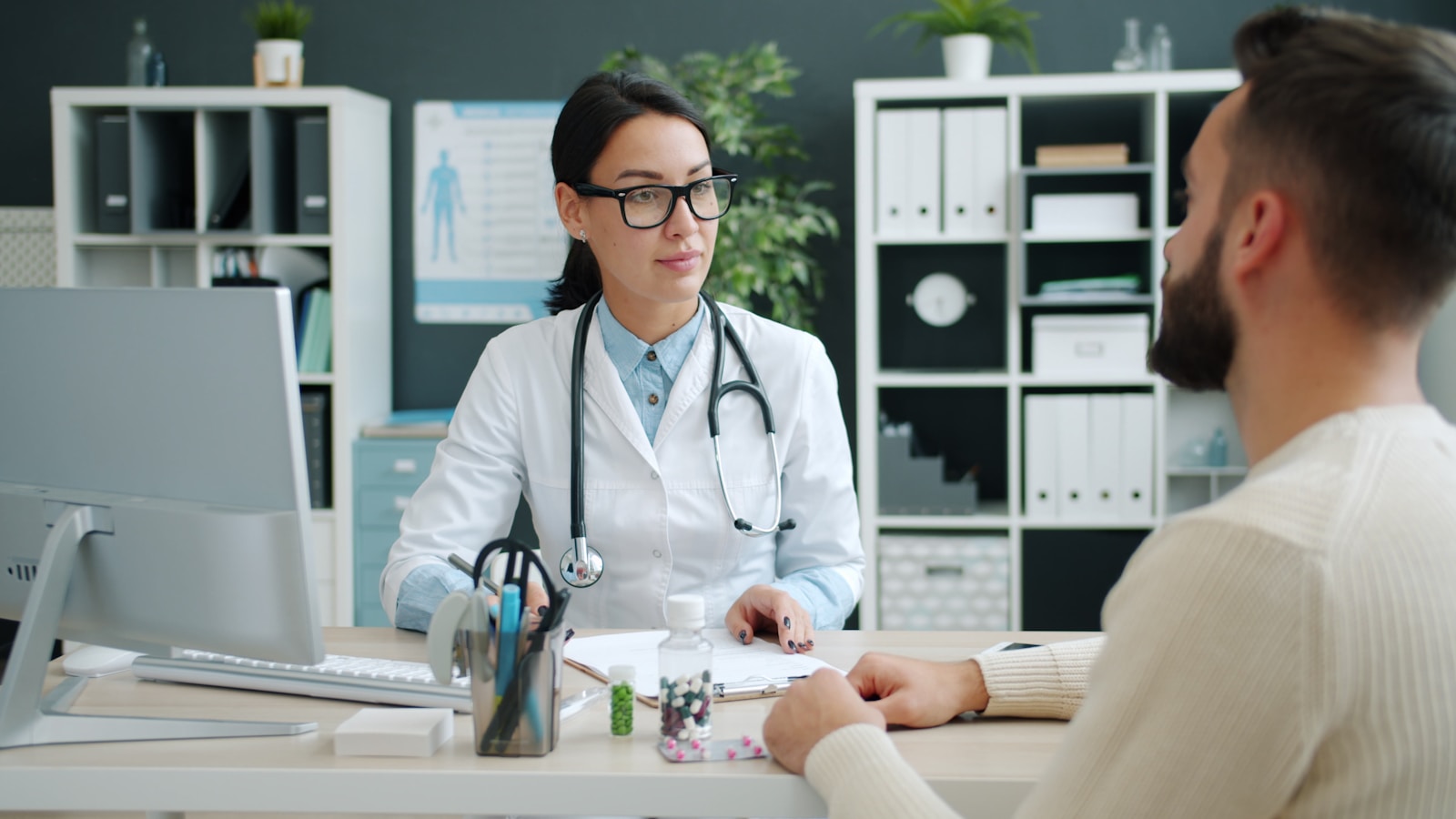 A patient in conversation with a healthcare professional at a pharmacy consultation, representing Getmeds Healthcare's role in connecting patients with essential medicines.